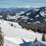 Panoraamanäkymä ihmisten hiihto alas rinteeseen ja oberau Wildschönau talvella aurinkoisena päivänä vuoristossa hiihtokeskus Alpbachtal, Wildschönau, Itävalta