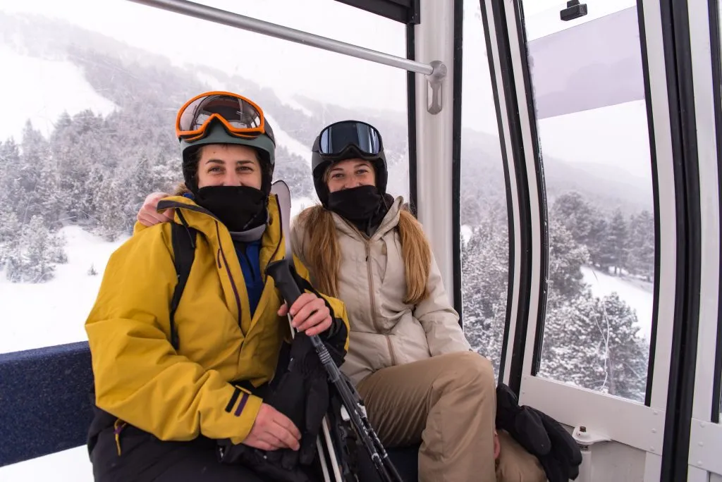Due giovani ragazze bionde su una gondola di una stazione sciistica in inverno