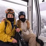 Due giovani ragazze bionde su una gondola di una stazione sciistica in inverno