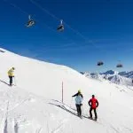 Quattro sciatori sulla pista da sci