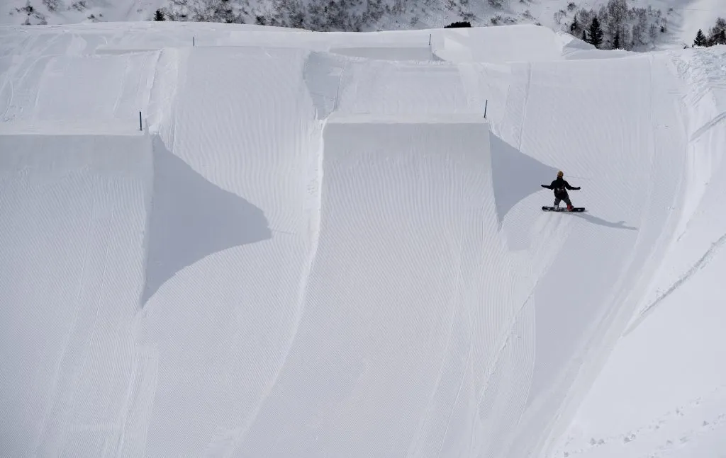 Lumilautailija ison kickerin vieressä Snowparkissa St.Anton am Arlbergissa, Itävallassa.
