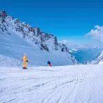 St. Anton am Arlberg. 10. maaliskuuta 2022. Ihmiset hiihtovaatteet liukuvat alas rinnettä lumisella vuorella hiihtokeskuksessa kauniina aurinkoisena päivänä, Hiihtäjät hiihtävät alamäkeä lumisella vuorella.