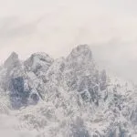 Wilder Kaiser in Tirol Österreich mit ersten Schnee im Jahr umhüllt von Wolken und Nebelschwaden.